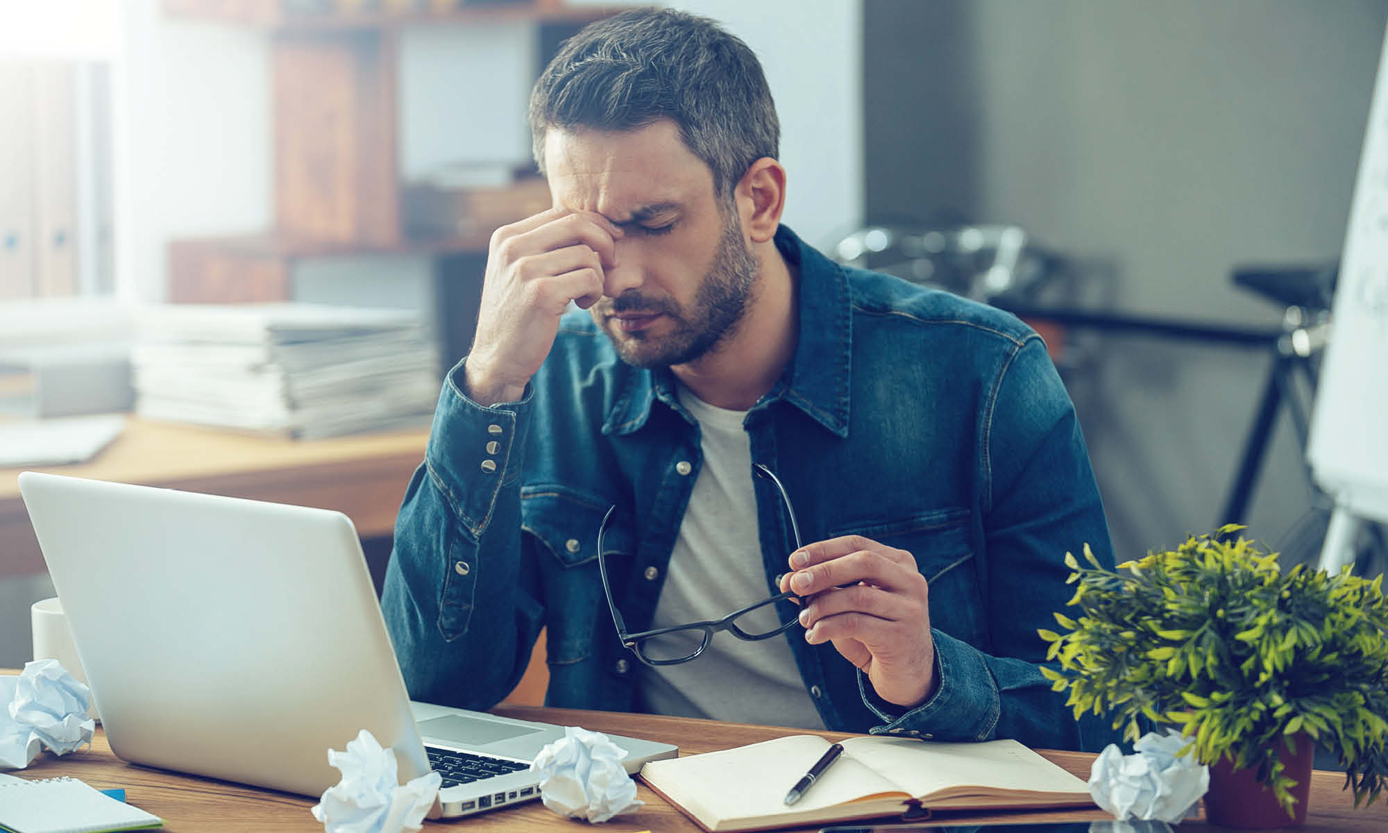 Stressed, disengaged new employee working at his desk